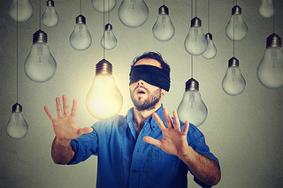 Alex-blindfolded-man-walking-through-lightbulbs-searching-bright-idea-picture-id5.jpeg